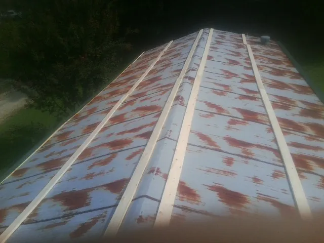 Rusted metal roof panels with new wood purlins before replacement — Storm Damage Roof Repair in Sims by Roofing Brothers